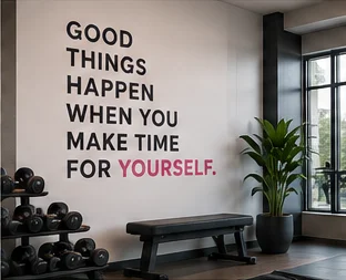 Training area with dumbbells and a bench beneath a wall that reads: Good things happen when you make time for yourself
